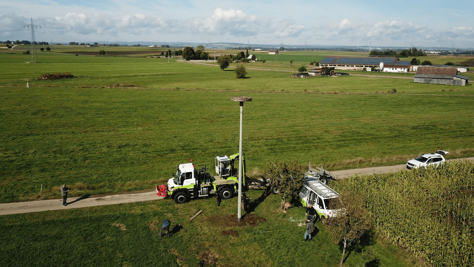 Auf einem Feld bei Neudingen stellte naturenergie netze einen alten Strommast extra für eine „klappernde“ Zweitnutzung auf: Seine Metallplattform mit Weidengeflecht soll Jungstörchen als Nestbauhilfe eine sichere Bauplatz-Alternative zur nahegelegenen Freileitung bieten. (Foto: WESPO/Rolf Wetzel)